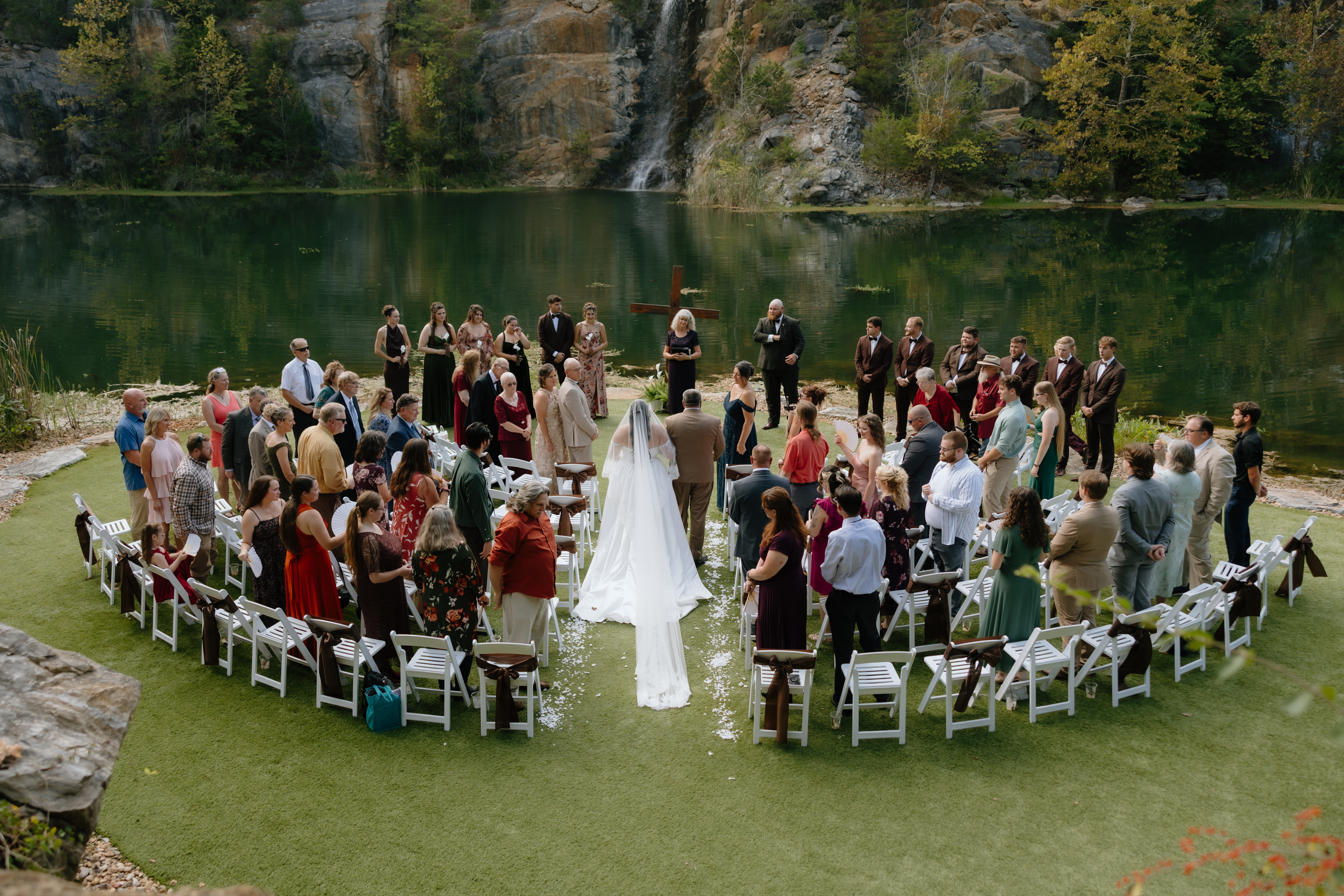 A couple leaning close together on their wedding day, with the bride holding a colorful bouquet.